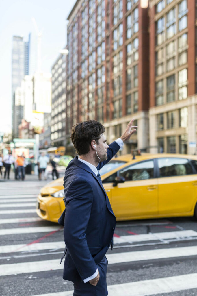 Businessman In The Streets Of Manhattan Hailing A Cab 682x1024